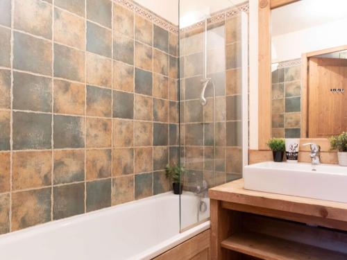 ein Badezimmer mit Badewanne und Waschbecken in der Unterkunft Appart centre Saint-Lary avec piscine, sauna et parking - FR-1-296-425 in Saint-Lary-Soulan