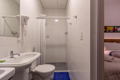 a bathroom with a toilet and a sink and a shower at BH Studios Hotel Brás in Sao Paulo