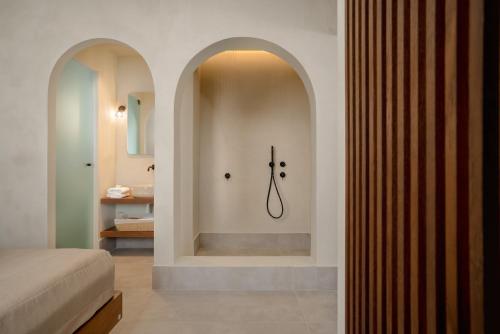 a bedroom with a bed and a shower in a room at Polis of Naxos Stylish Suites in Naxos Chora