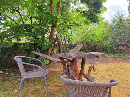 a wooden table and two chairs next to a tree at Schloss Hilbringen in Merzig