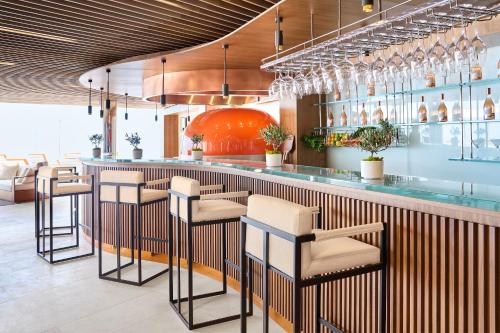 a bar in a restaurant with stools at The Maybourne Riviera, Maybourne in Roquebrune-Cap-Martin