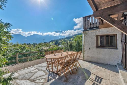 - une table et des chaises sur une terrasse avec vue sur les montagnes dans l'établissement Appartement Snow - Welkeys, à Combloux
