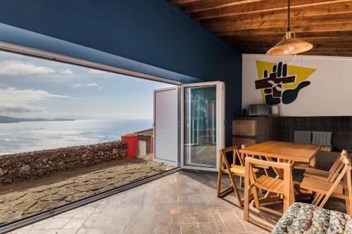 una sala da pranzo con tavolo e vista sull'oceano di Casa do Cascalho a Ribeira Grande