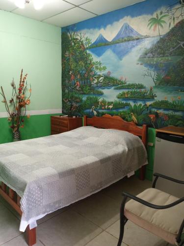 a bedroom with a large painting on the wall at Hospedaje Hefziba in Moyogalpa