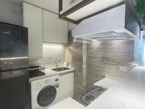 a kitchen with a washing machine and a sink at DEPARTAMENTO CENTRICO CON COCHERA - CORDOBA Argentina- in Cordoba