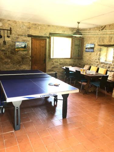 tavolo da ping pong in una sala con tavoli e sedie di Mas Molladar a Camprodon