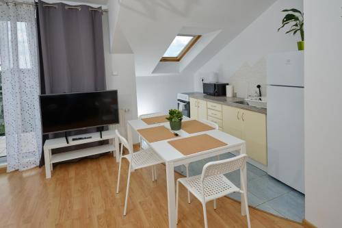 kuchnia ze stołem z krzesłami i telewizorem w obiekcie Apartament Słoneczny 7 w mieście Opole