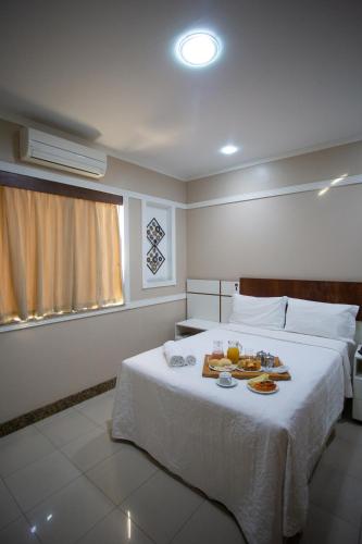 a hotel room with a bed with food on it at Benvenuto Palace Hotel in Governador Valadares