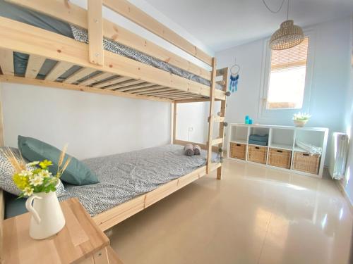 een slaapkamer met 2 stapelbedden en een tafel bij Topitos Apartment Casc Antic in Tarragona