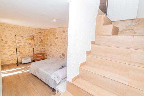 a bedroom with a bed and a staircase at Casa Rural La Cocinilla del Pato Sagasta in Alcalá del Júcar