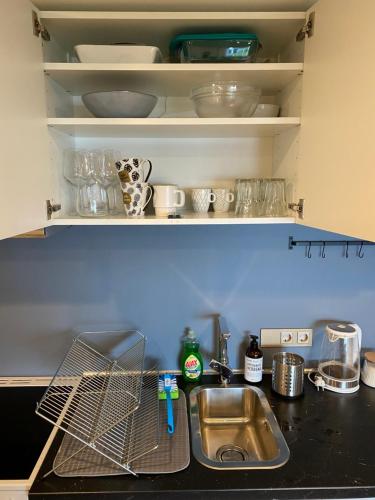 a kitchen sink with a dish drying rack above it at Great place with view to the mountains and fjord in Ålesund