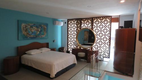 1 dormitorio con cama y espejo en Gorgeous Duplex Mamitas Beach jacuzzi 3bd lock-out, en Playa del Carmen