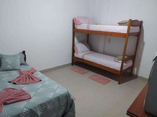 1 Schlafzimmer mit 2 Etagenbetten und einem TV in der Unterkunft Miguel Departamentos 1 in Puerto Iguazú