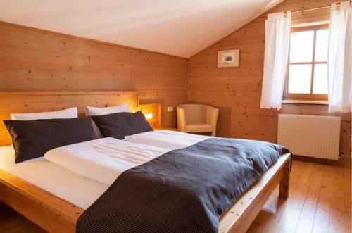 ein Schlafzimmer mit einem großen Bett in einem Zimmer mit Holzwänden in der Unterkunft Oberwinklgut in Bischofshofen