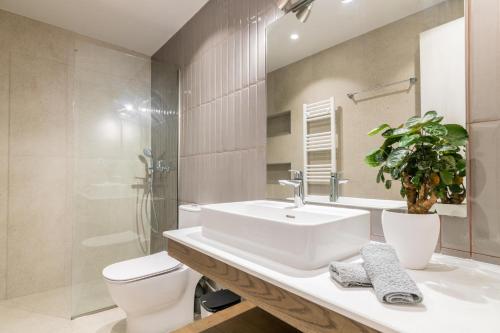 a white bathroom with a sink and a toilet at ANEMA STYLISH RESIDENCE in Zakynthos Town
