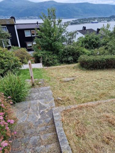 a stone path in a yard with a house at Great place with view to the mountains and fjord in Ålesund