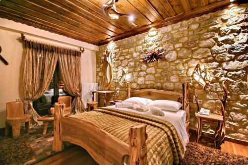 a bedroom with a bed and a stone wall at En Dimitsani in Dhimitsana