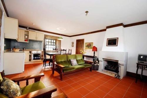 a living room with a couch and a fireplace at Agro-Turismo - Quinta do Pinheiro in Cavadoude