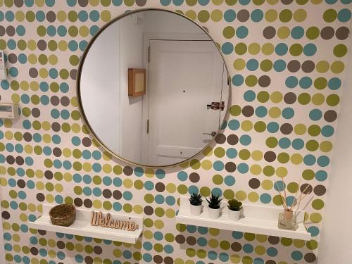 a bathroom with a mirror on a wall with polka dots at Topitos Apartment Casc Antic in Tarragona