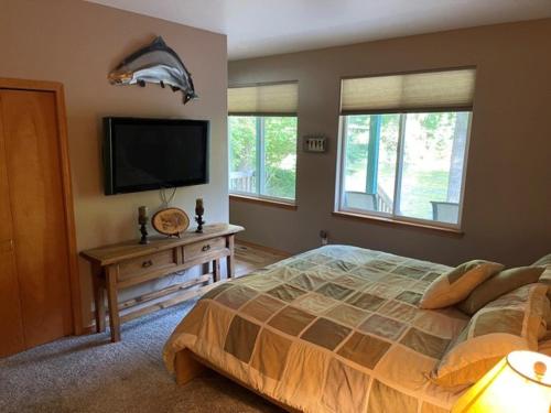 a bedroom with a bed and a flat screen tv at Cozy Riverfront Retreat in Leavenworth