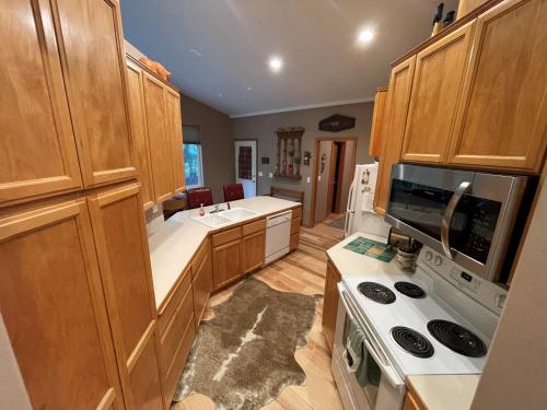 a kitchen with wooden cabinets and a stove top oven at Cozy Riverfront Retreat in Leavenworth