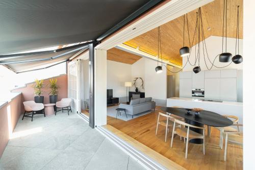 a living room and dining room with a table and chairs at Mouzinho Village River in Porto