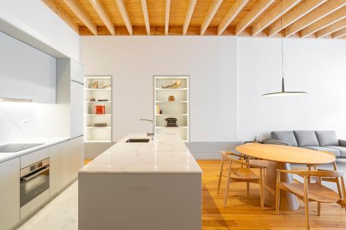 a kitchen with white walls and a wooden ceiling at Mouzinho Village River in Porto