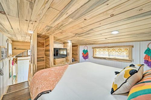 Towaoc的住宿－Boho Bliss Tiny Home with Fireplace, Fire Pit，一间卧室设有一张大床和木制天花板