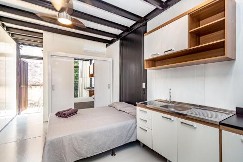 a small bedroom with a bed and a sink at 3x6 Lofts in Balneário Camboriú