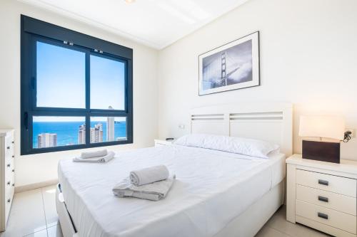 ベニドルムにあるGemelos 26 Resort Apartment 22E Levante Beachの白いベッドルーム(大型ベッド1台、窓付)