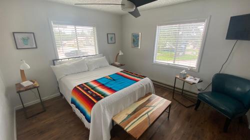 a bedroom with a bed and a blue chair at The Summit Inn in Cloudcroft