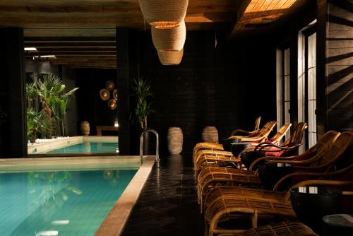 a pool with lounge chairs next to a swimming pool at Esquisse Design Hotel in Tʼelavi