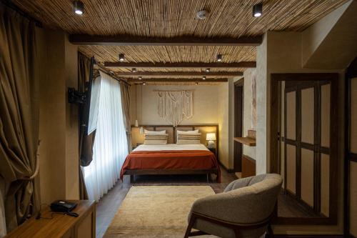 a bedroom with a bed and two chairs in it at ASHA ALAÇATI in Çeşme
