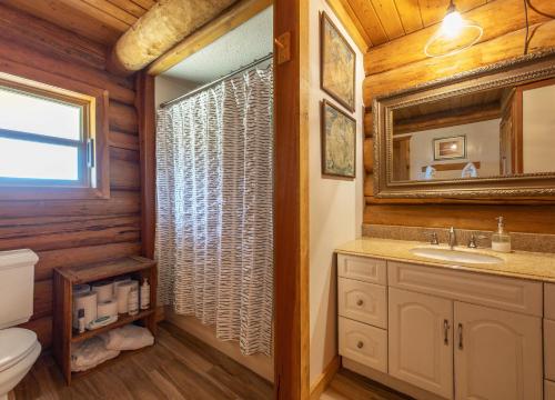 La salle de bains est pourvue d'un lavabo et d'un miroir. dans l'établissement Rowland Log Cabin home, à Lyle