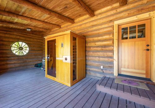 a wooden cabin with a door and a porch at Rowland Log Cabin home in Lyle