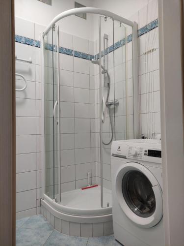 uma máquina de lavar roupa na casa de banho com um chuveiro em garncarska6 em Gdansk