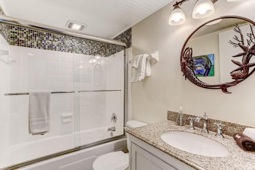 a bathroom with a shower and a sink and a mirror at Unobstructed Oceanfront View-Direct Beach Access-Oceanfront Pool-Amelia South L4 in Fernandina Beach