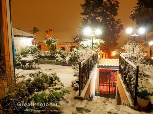 a garden covered in snow at night at Hotel Alafrangite in Plovdiv