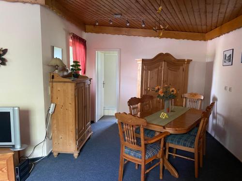 - une salle à manger avec une table et des chaises en bois dans l'établissement Chalet am See, à Sontra