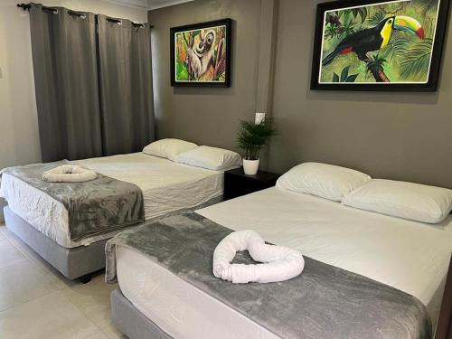 a room with three beds and a bird picture on the wall at La Posada del Mar in Dominical