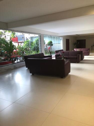a living room with couches and plants in a building at Palladium Apart Service in São Vicente