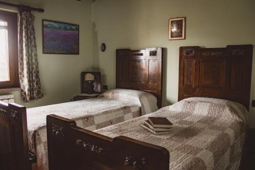 sypialnia z dwoma łóżkami i książką na stole w obiekcie Casa Tilde w mieście Palazzina