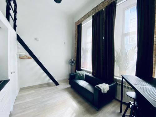 un soggiorno con un divano e due finestre di B&W Apartment a Riga