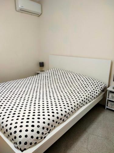 a bedroom with a bed with a black and white comforter at La Casa de Maia in Belpasso