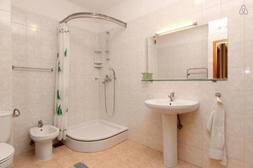 een badkamer met een wastafel, een toilet en een douche bij Apartment Happy Day in Split