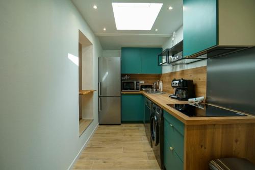 une cuisine avec des armoires bleues et un comptoir dans l'établissement The Semnoz charming apartment for 2 people close to the lake!, à Sévrier