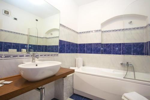 a bathroom with a sink and a tub and a toilet at Hotel PentHouse in Perugia