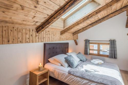 une chambre avec un lit et un plafond en bois dans l'établissement Appartement La Combe aux Loups - Welkeys, à Combloux