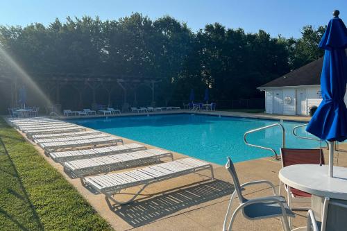 a swimming pool with lounge chairs and a table at 3 Mi to Bethany Beach Gem with Deck and Pool Access in Ocean View
