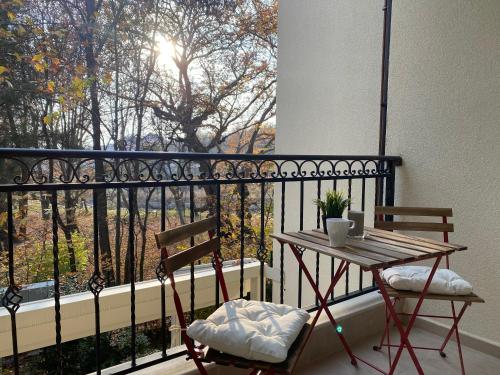 a table and two chairs on a balcony with a window at Green park Sandanski in Sandanski